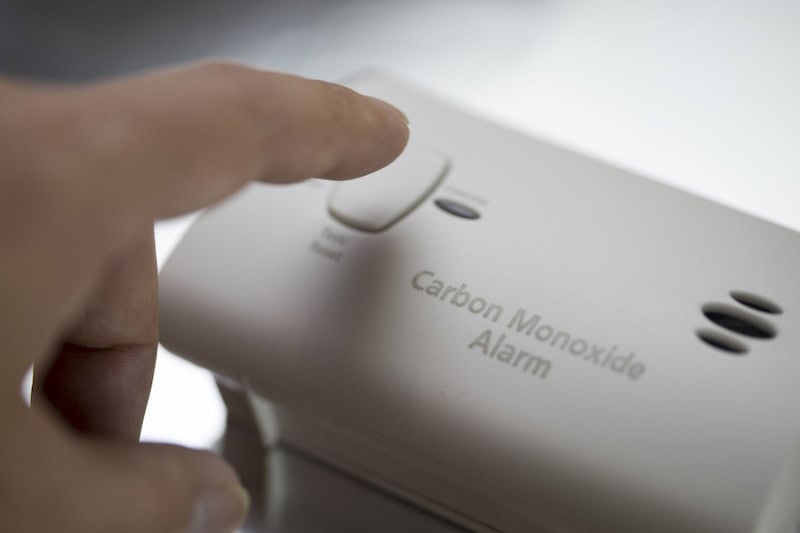 Homeowner testing their home's carbon monoxide alarm.